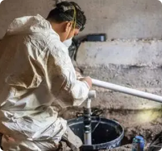 Crawl Pros professional working on a sump pump for a water remediation service in a crawl space