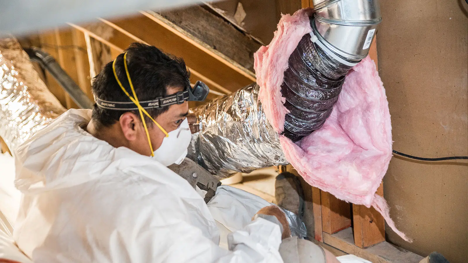 Crawl Pros professional installing a duct sealing and insulation in an attic
