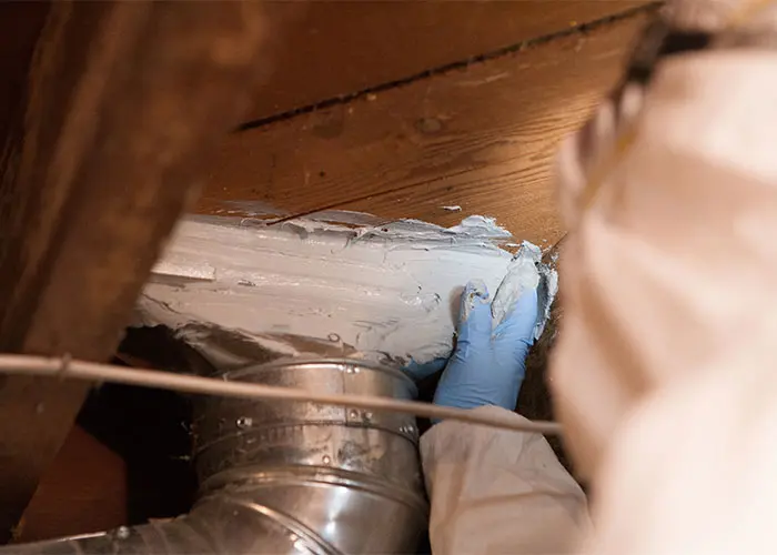 Crawl Pros professional sealing a duct in a crawl space